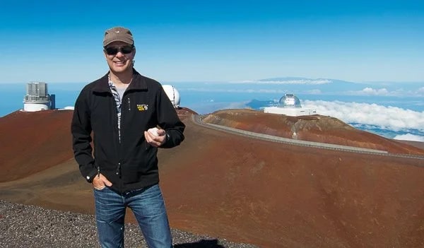 Carl on Mauna Kea's 13,803 ft summit with snowball in hand. This is one of the best sites in the world for astronomical observation, hence the numerous observatories.