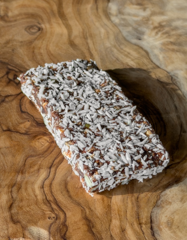 A coconut-coated evening snack bar on a wooden surface