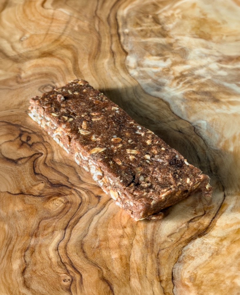 A dense chocolate pre-workout fuel bar on a wooden surface